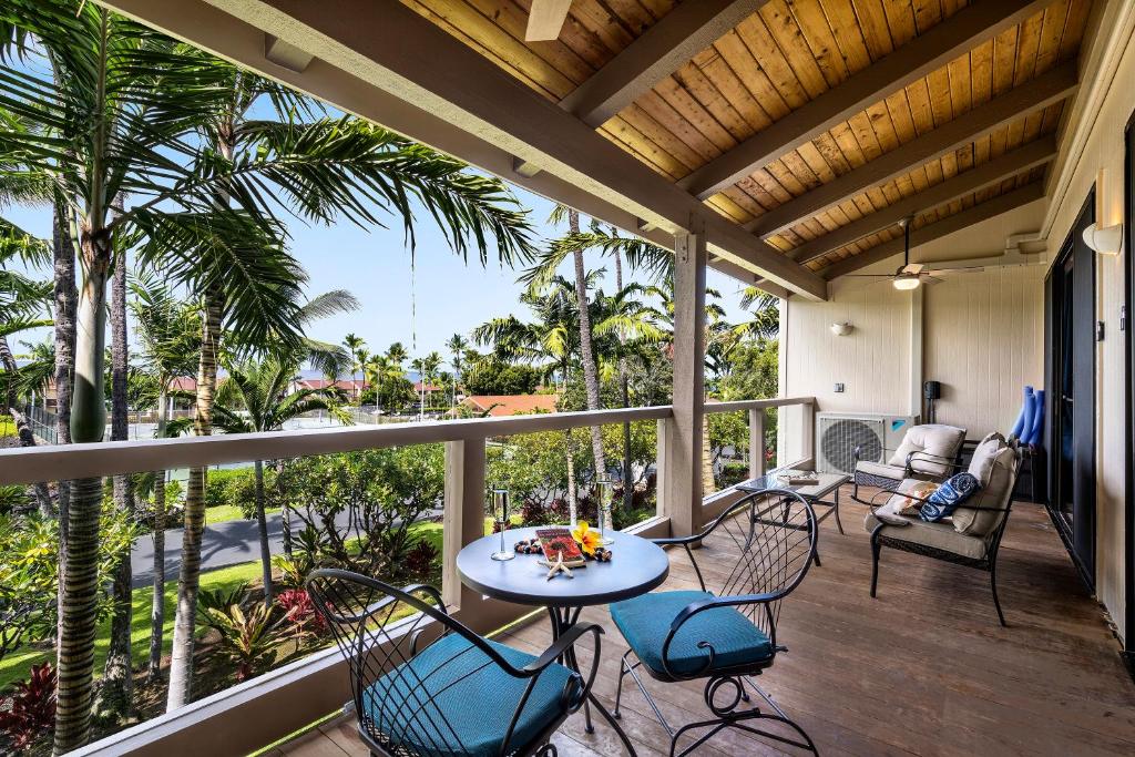 weranda ze stołem, krzesłami i palmami w obiekcie Keauhou Kona Surf Racquet 9303 w mieście Kailua-Kona