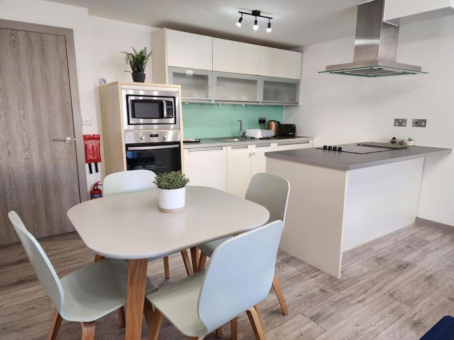 a kitchen with a white table and chairs in a kitchen at Horizon House, Luxury 2-Bedroom Flat 3 in Oxford