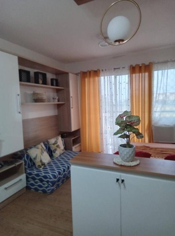 a kitchen with a living room with a potted plant at CasaMia Studio Sanremo Oasis Cebu in Talisay
