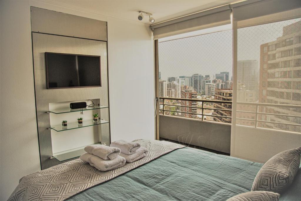 a bedroom with a bed and a large window at Moderno y Estiloso Excelente Ubicación, Las Condes in Santiago