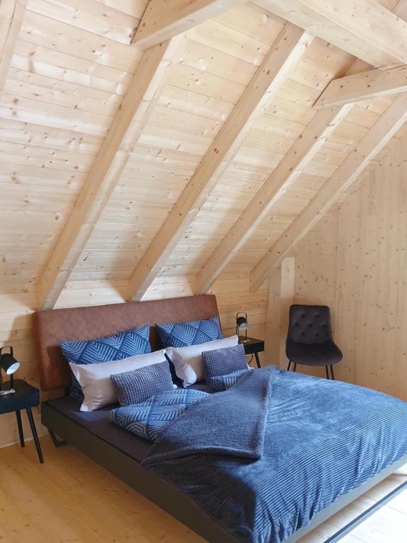 1 dormitorio con 1 cama grande con almohadas azules en Odenwald-Lodge mit Infrarotsauna und E-Ladestation "Haus Purpur", en Reichelsheim