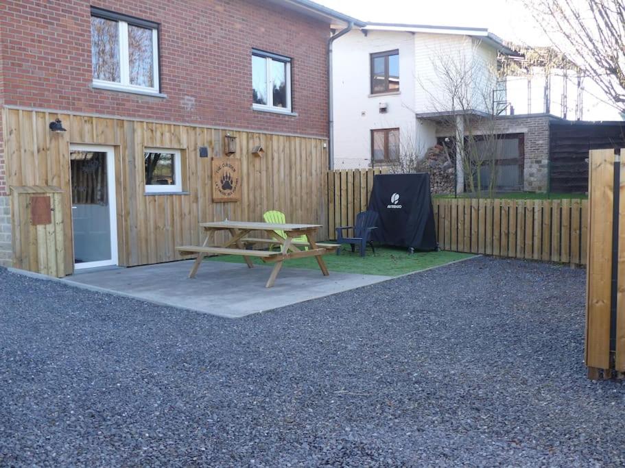 a backyard with a picnic table and a fence at La tanière des oursons in Aywaille