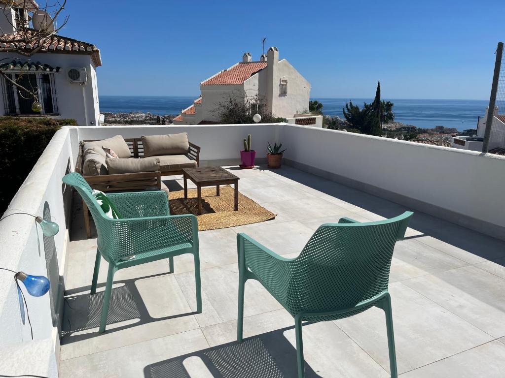 a patio with two chairs and a table and a couch at Wave watch terrace apartment in Benalmádena