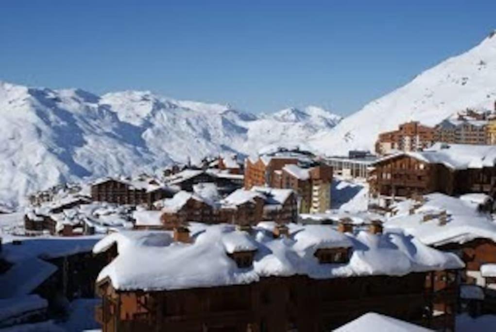 una ciudad cubierta de nieve con montañas en el fondo en Appartement 45m2 - 7 personnes - exposition sud, en Val Thorens