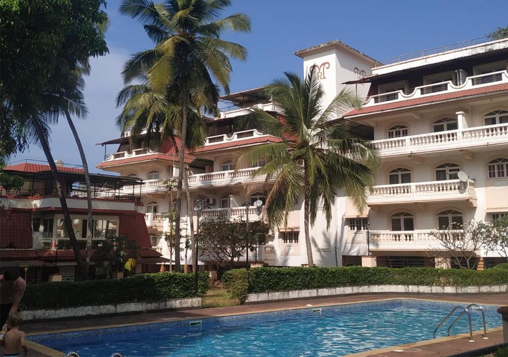 a hotel with a swimming pool in front of a building at 'Escape to the heavens with our sky view' 1BhK apartment,WIFI, Gym, pool & 5 min walk to Colva Beach in Colva