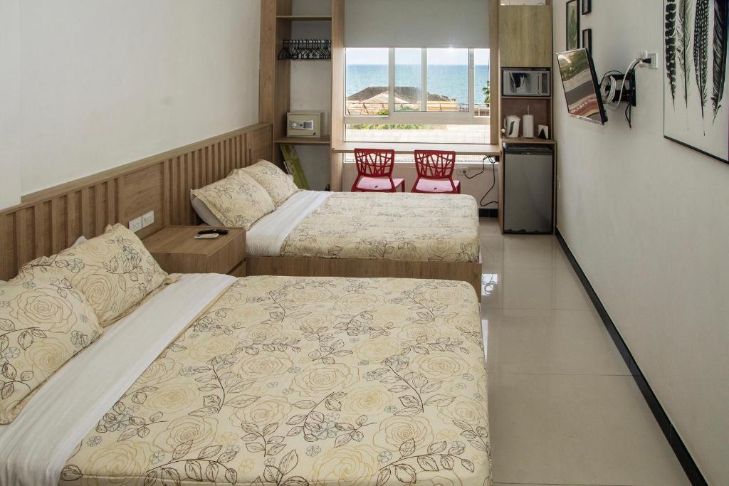 カルタヘナ・デ・インディアスにあるApartamento Ganem 505aのベッドルーム1室(ベッド2台付)、キッチン(椅子2脚付)