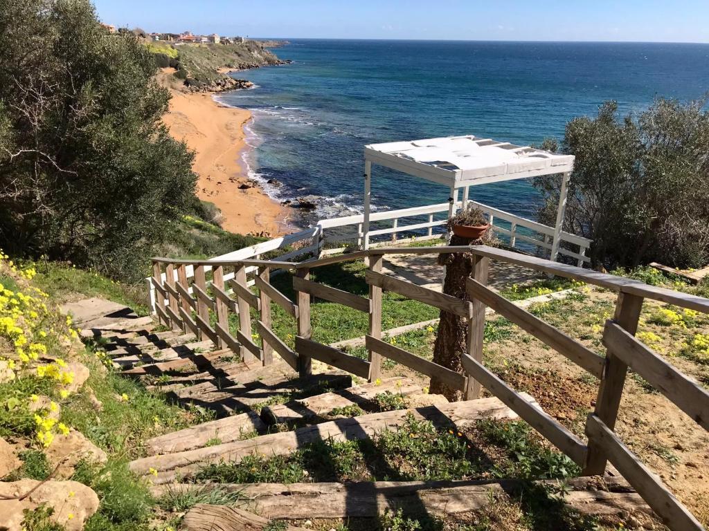 una recinzione con un baldacchino in cima a una spiaggia di casa indipendente con accesso diretto al mare a Ovile la Marina