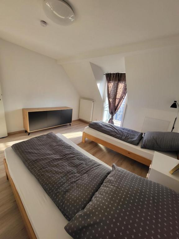 a bedroom with two beds and a flat screen tv at Beautiful Cozy apartments close to lakes and nature parks in Schwandorf in Bayern