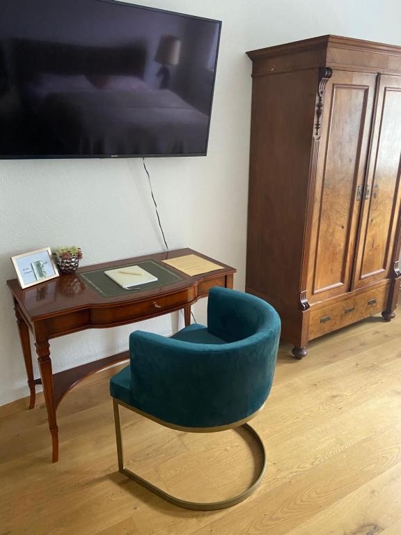 a room with a chair and a desk with a tv at Schöne Ferienwohnung mit kostenlosem Parkplatz in Cottbus