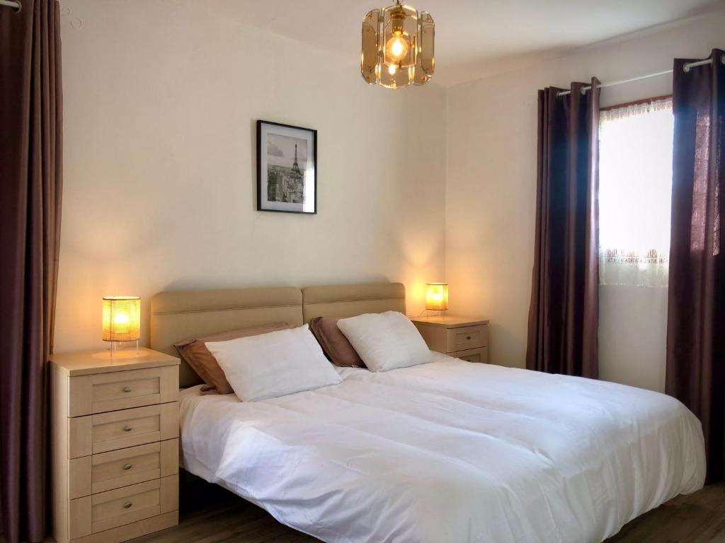- une chambre avec un lit blanc, deux lampes et une fenêtre dans l'établissement Maison Lavande le grande gite, à Menetou-sur-Nahon