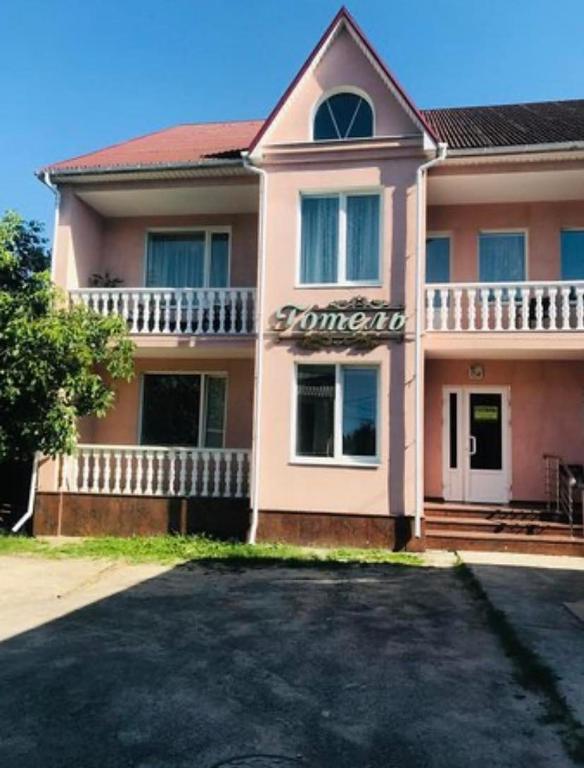 una casa rosa con un vialetto di fronte di Готель Корнет a Umanʼ