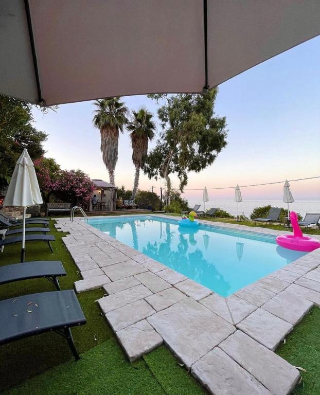 une piscine avec des chaises et un parasol dans l'établissement Residence VILLA MOROSI - Favone, à Conca