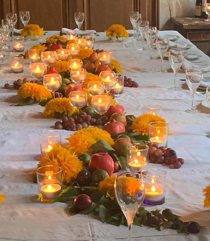 a long table with candles and fruit and flowers at La Maison Saint Joseph in Crépy-en-Valois