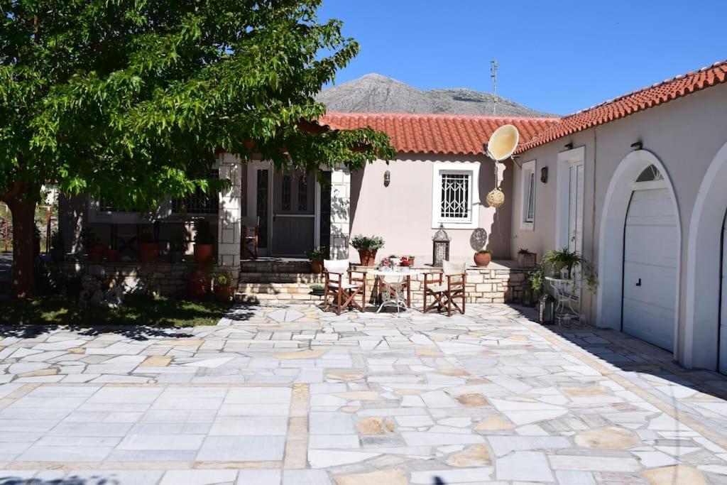 a patio with a table and chairs in front of a house at Βίλα Εύη in Lygourio