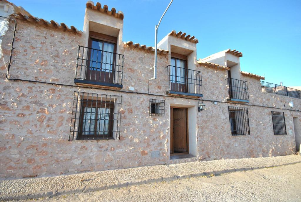 - un vieux bâtiment en pierre avec des fenêtres et une porte dans l'établissement Los Garriolos, à Terrinches
