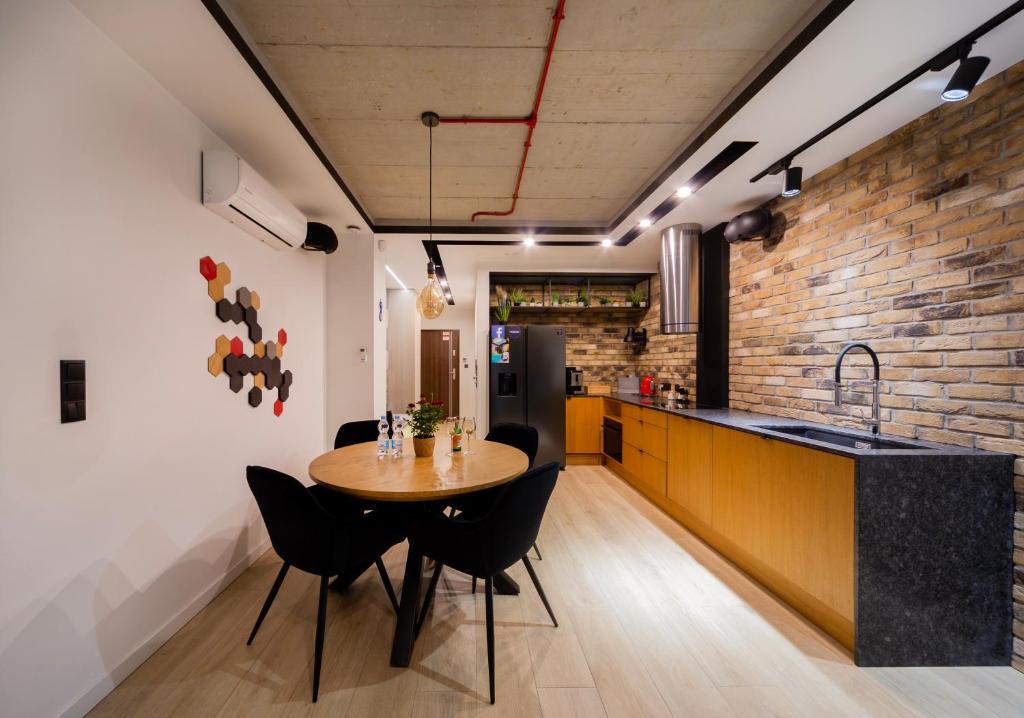 a kitchen and dining room with a wooden table and chairs at Apartament Aleja Wolności in Nowy Sącz