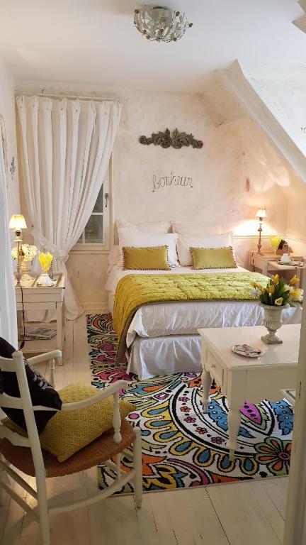 サン・ジェルヴェ・ラ・フォレにあるChambres d'hôtes Jardin D'ivoireのベッドルーム1室(ベッド1台、テーブル、椅子付)