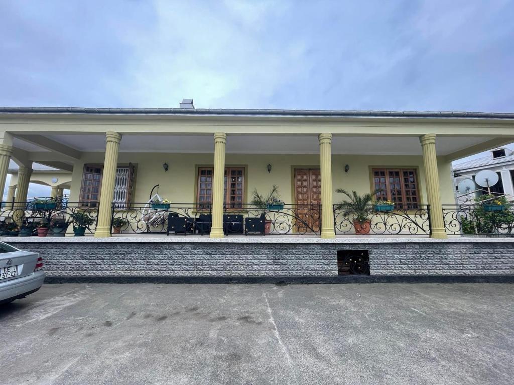 un bâtiment avec des colonnes et un balcon avec des plantes dans l'établissement Medo's home, 