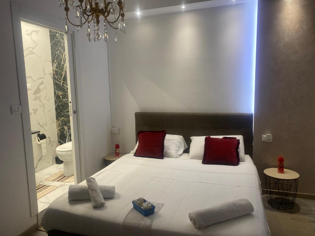 1 dormitorio con 1 cama con almohadas rojas y baño en Zola Centro, en Zola Predosa