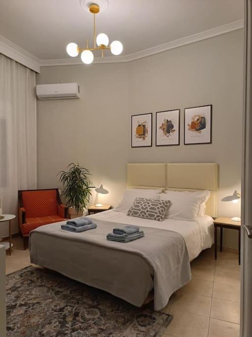 - une chambre avec un grand lit et une chaise dans l'établissement Κεντρικό ευρύχωρο στούντιο με parking, à Larissa