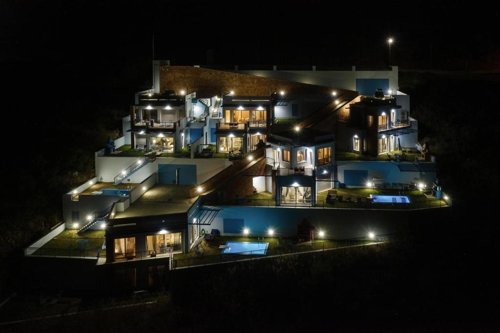 duży dom jest oświetlony w nocy w obiekcie Skorponeria Bay Luxury Villas w mieście Skroponeria