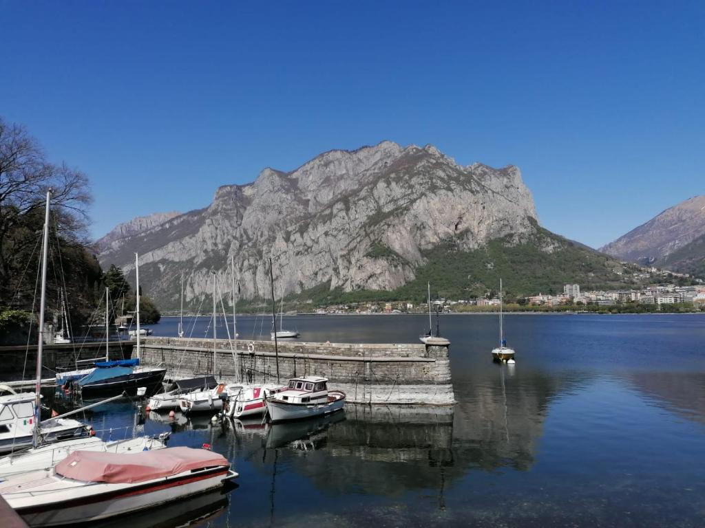 a group of boats docked at a marina with a mountain at la casa del barcaiolo in Malgrate