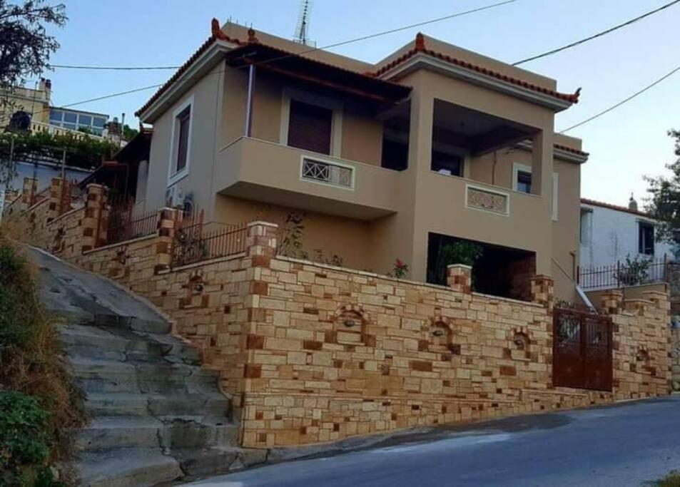 una casa con una pared de ladrillo junto a una calle en Gavrilis Apartments en Nénita