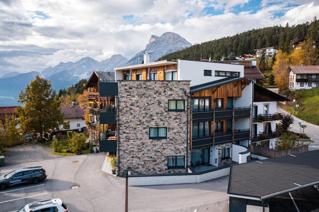 a building with a car parked in a parking lot at Panorama Residence Mösern in Seefeld in Tirol