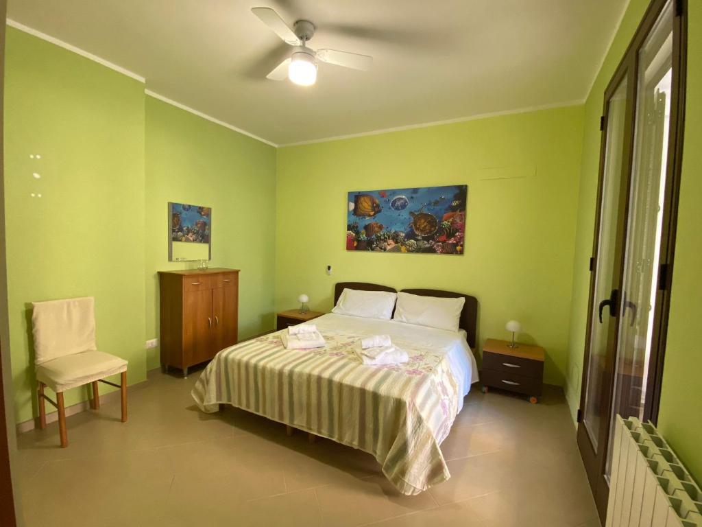 a bedroom with a bed and a ceiling fan at VILLA DELLE POMELIE in Isola delle Femmine