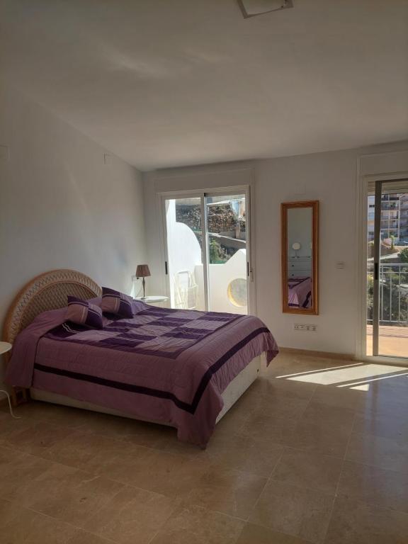 - une chambre avec un grand lit et un couvre-lit violet dans l'établissement Casa BuenaVista Albunol, à Albuñol