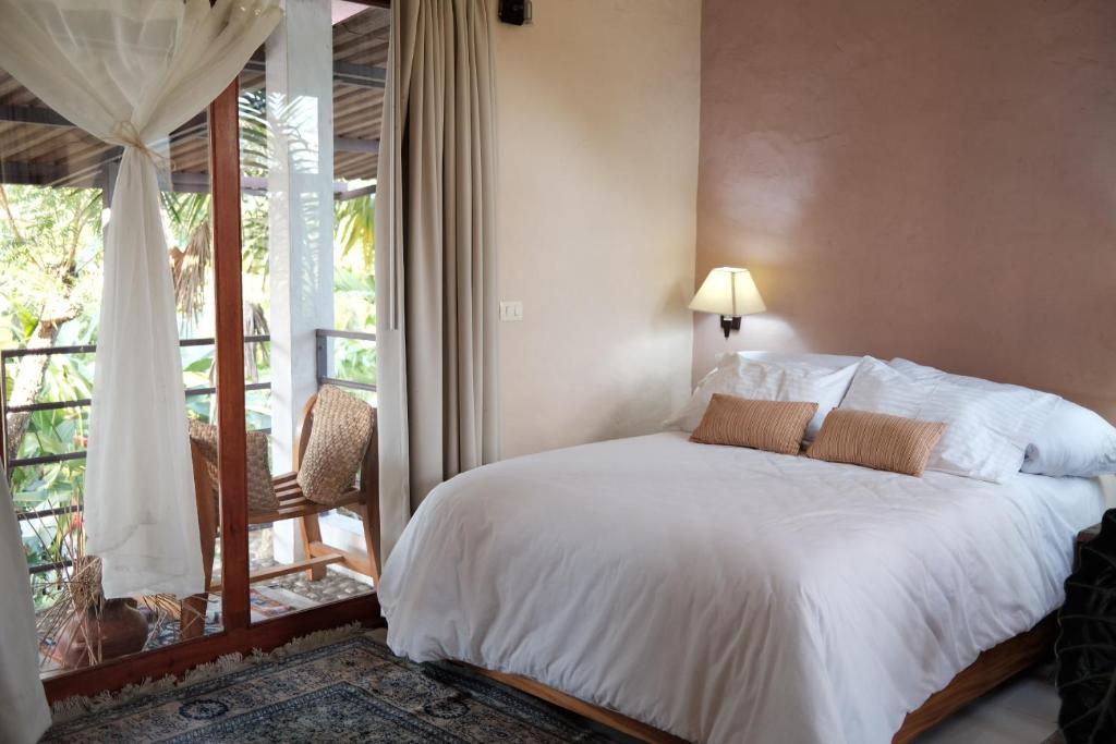1 dormitorio con cama blanca y balcón en kaabna spa, en Villahermosa