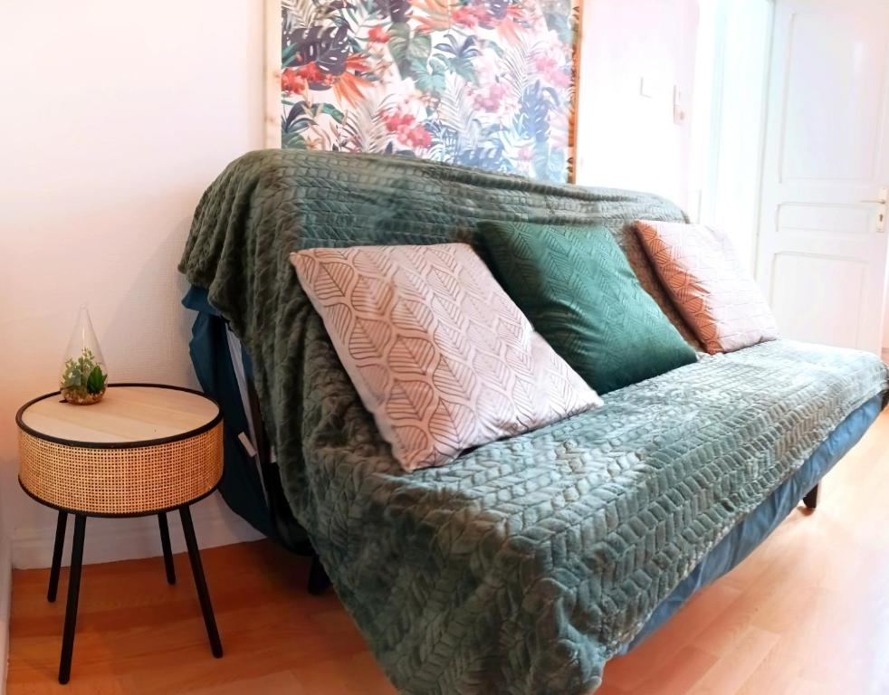 Le studio Naturel في هينان بومونت: أريكة خضراء عليها وسائد في الغرفة