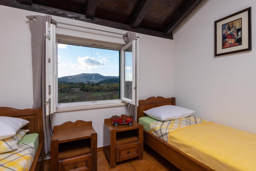 2 camas individuais num quarto com uma janela em Holiday Home Kuna Pelješac em Kuna Pelješka
