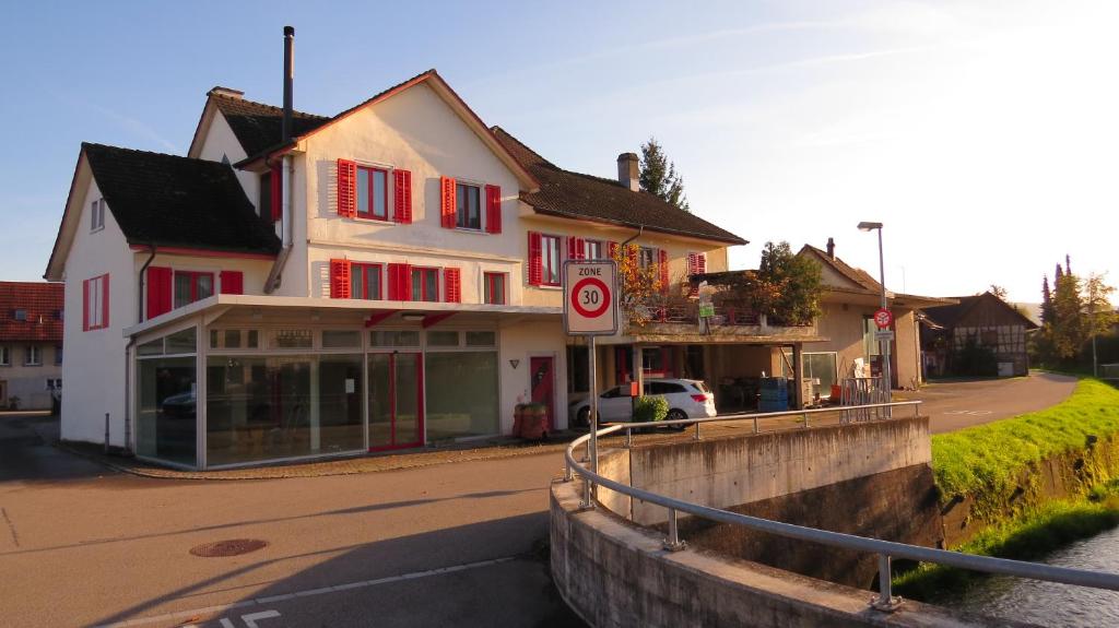 un edificio con persianas rojas en una calle en Dorf-Schmiede - Bed und Breakfast, en Müllheim