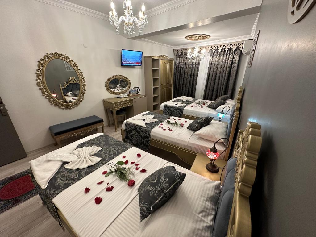 イスタンブールにあるEthnica Suitesのベッドルーム1室(ベッド2台、花のテーブル付)