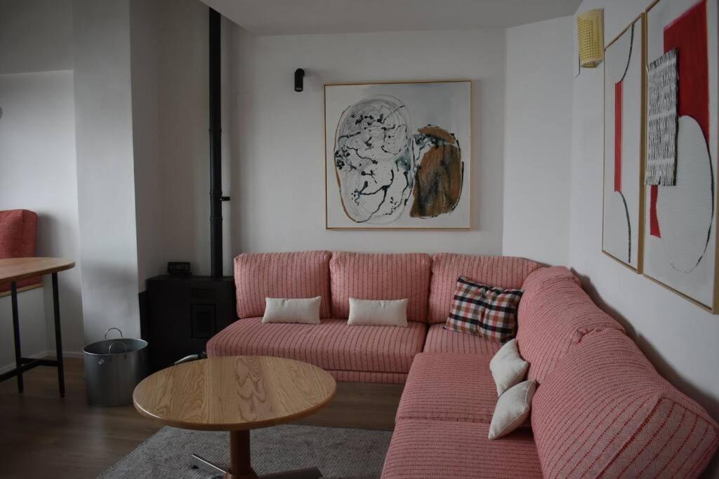 a living room with a pink couch and a table at ¡A pie de pistas! in Monachil