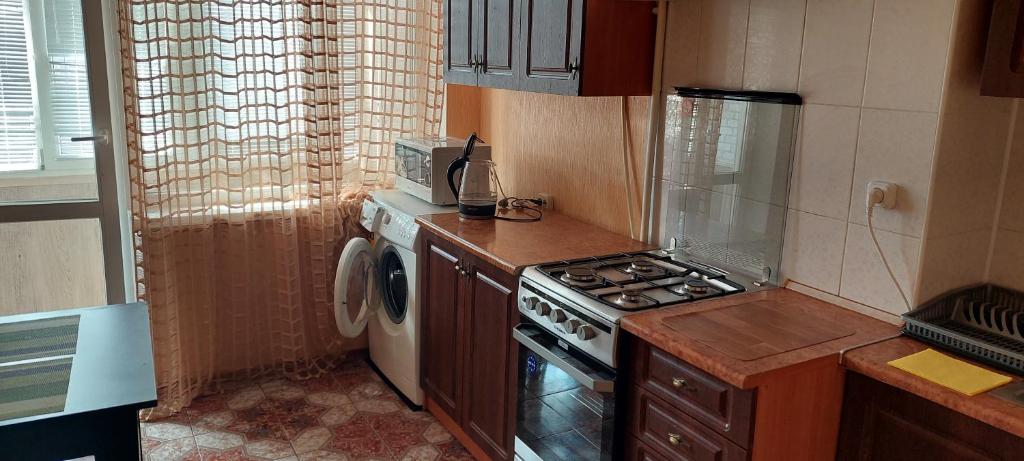 a kitchen with a stove and a washing machine at Центр 3 слободская АТБ in Mykolaiv