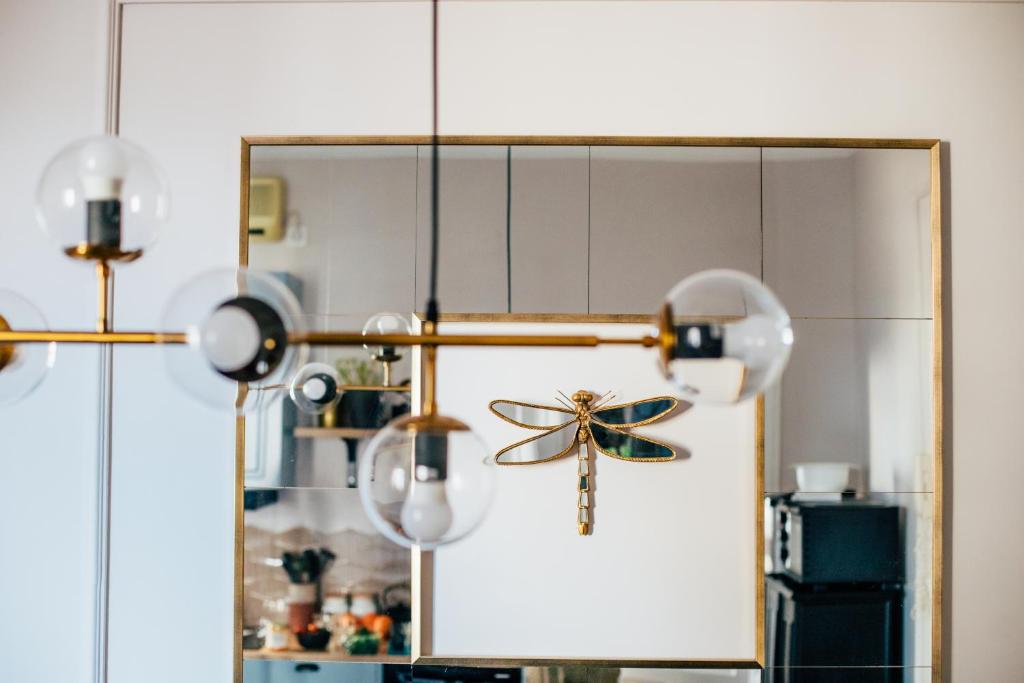 een kamer met een spiegel en een kroonluchter bij Dragonfly Residence in Belgrado