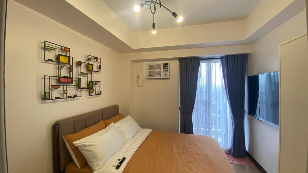 Cozy 1 Bedroom Condominium in Balintawak Quezon City tesisinde bir odada yatak veya yataklar