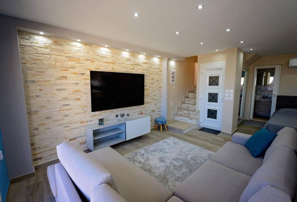 a living room with a couch and a flat screen tv at Lia's apartment in Kalymnos