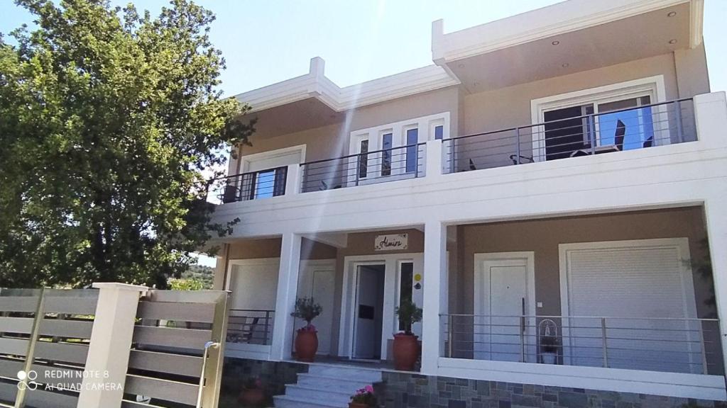 a large white house with a balcony at Almira Ghouse in Almiropotamos