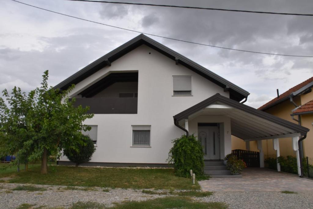 a white house with a black roof at Kuća za odmor „Slavonska Lola“ in Nuštar