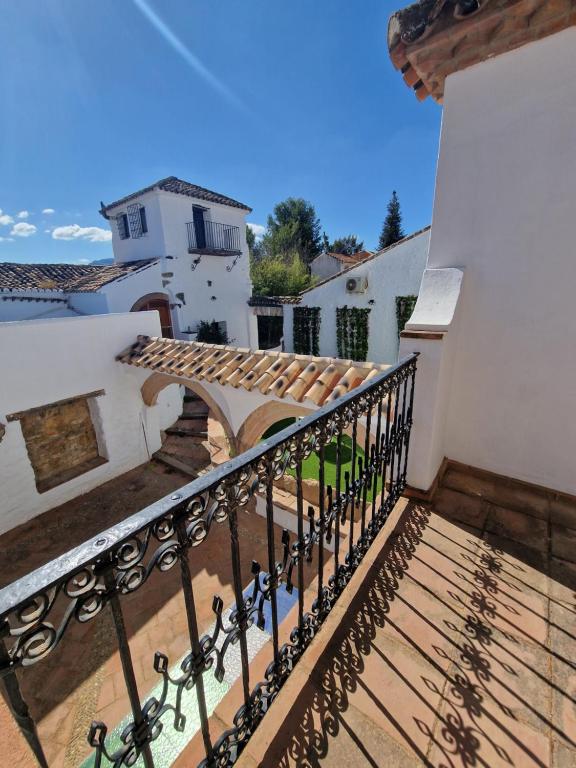 een balkon van een huis met een houten leuning bij Canaan Boutique Hotel Ronda in Ronda