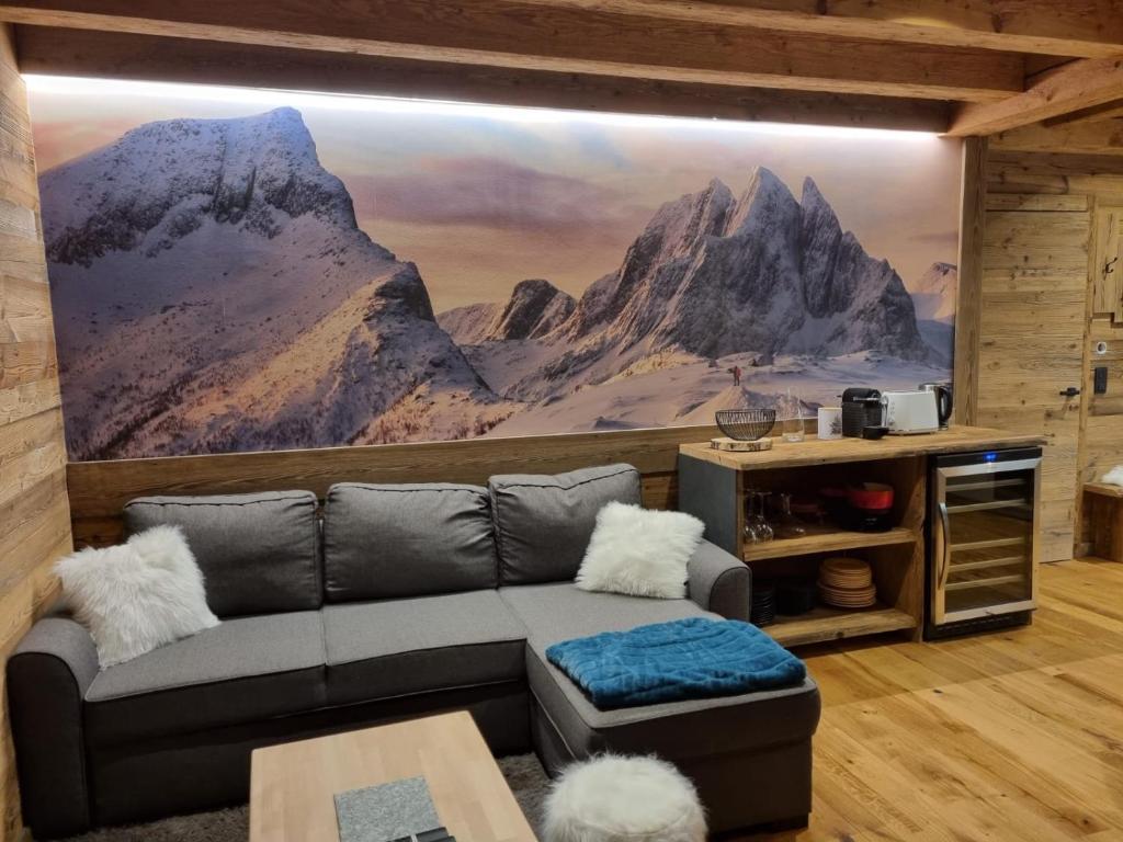 sala de estar con sofá y mural de montaña en Appartement haut standing Arêches beaufort, en Arêches