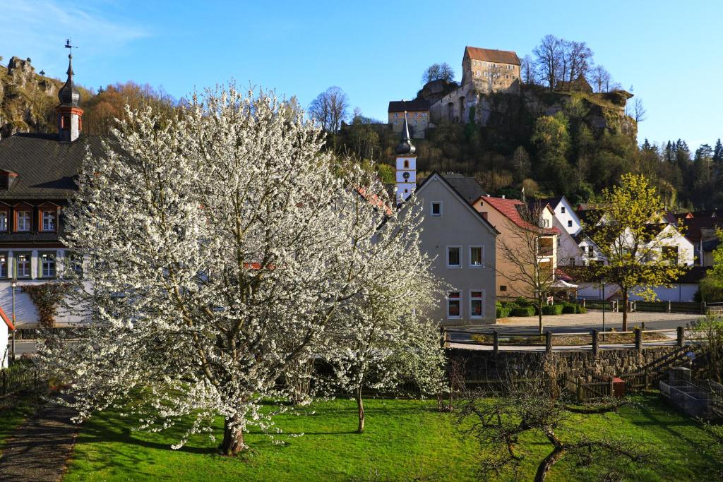 a tree with white flowers on it in a village at Minderleins Apart in Pottenstein