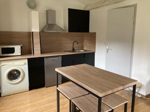 a kitchen with a table and a washing machine at Campita in Omessa