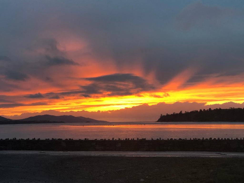 una puesta de sol sobre un gran cuerpo de agua en Dromkeal View apartment, en Cork