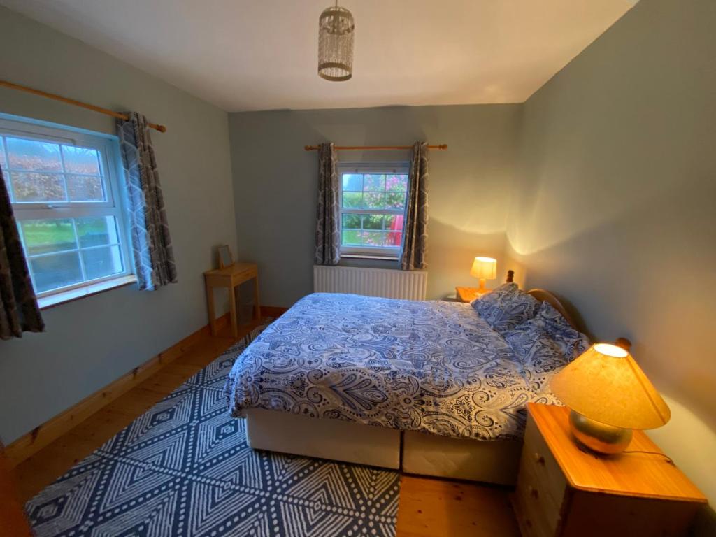 a bedroom with a bed and a table with a lamp at Dromkeal View Apartment in Cork