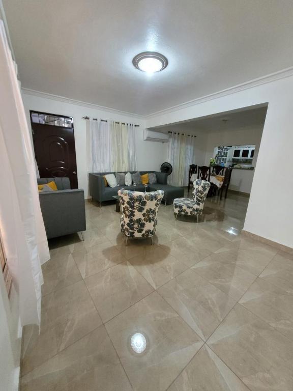 a living room with a couch and chairs at Departamento Rosa in Santo Domingo