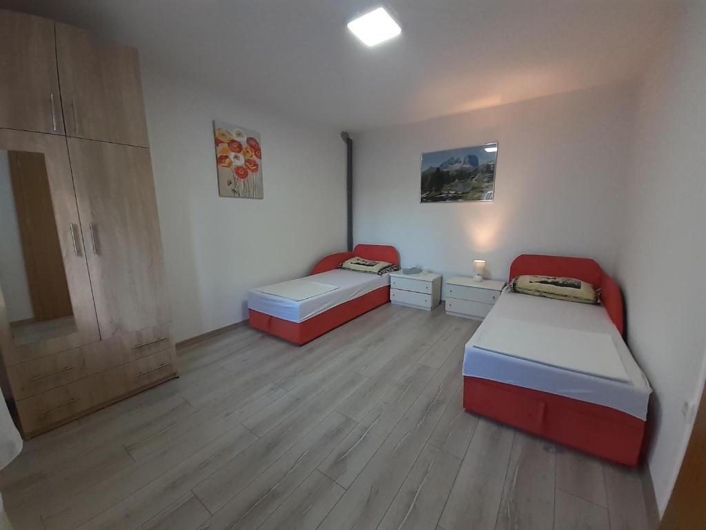 2 camas en una habitación con suelo de madera en Apartman Prenj, en Konjic